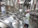 1650429111-male-work-inspection-process-powder-cellar-with-vertical-stainless-steel-tanks-factory